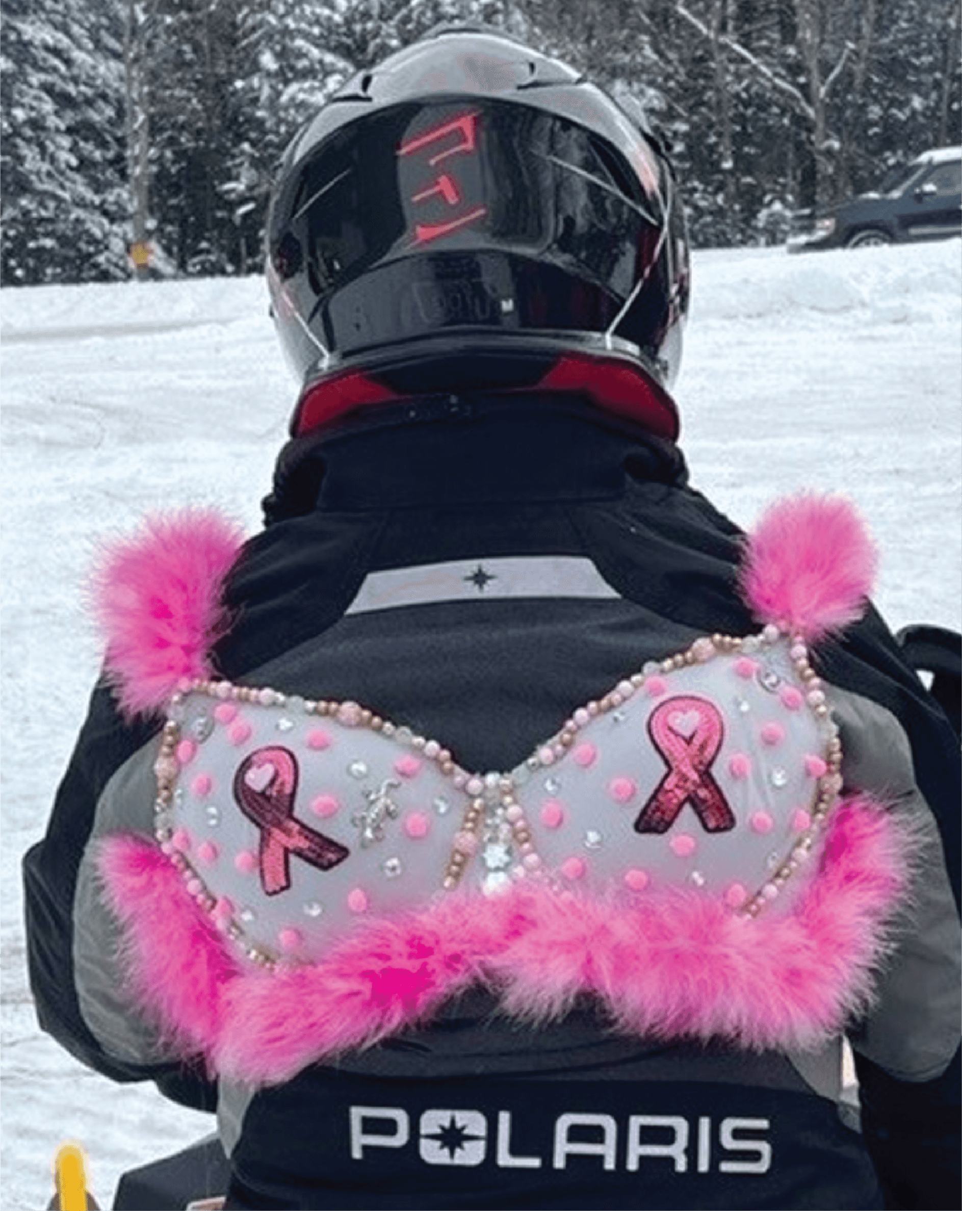 A snowmobiler showing breast cancer awareness pride with pink ribbons